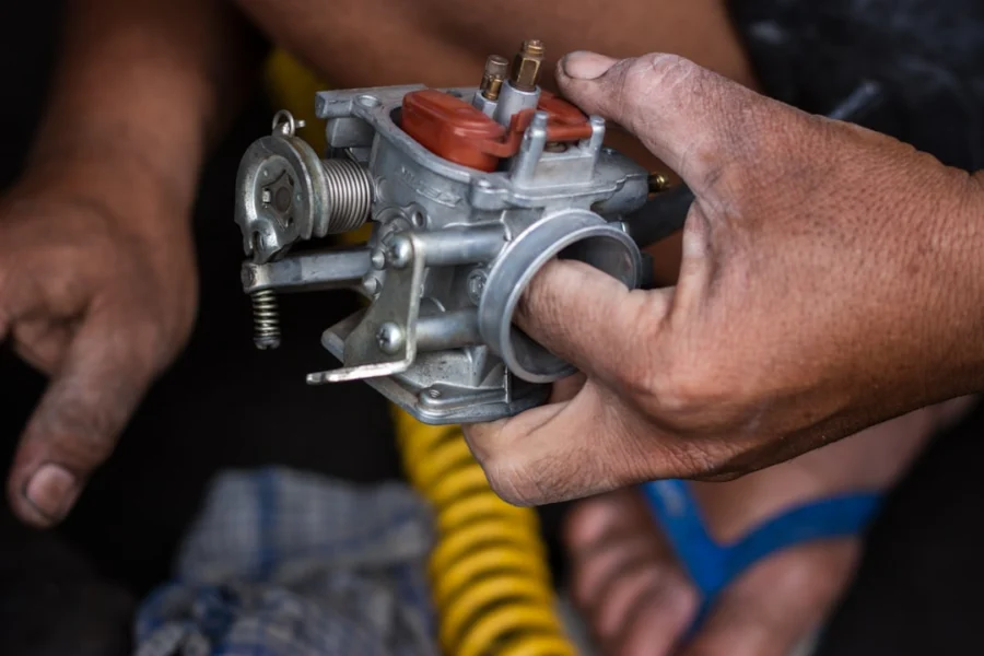 Mekanik sedang mempraktikkan cara memperbaiki karburator motor banjir dengan membersihkan jarum pelampung